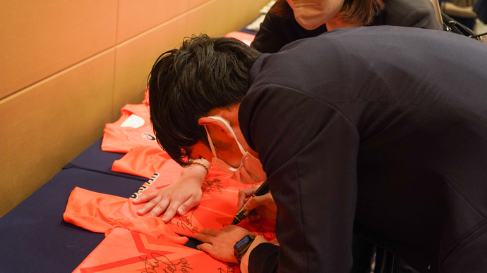 【陸連アワードの舞台裏】ファンの方へお渡しするTシャツにサイン：真剣な表情でサインをする真野友博選手！