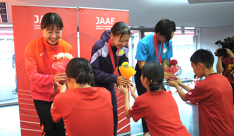 【第110回日本選手権】DAY2 表彰式:子供たちから花束を手渡されて笑顔を見せる女子800mのメダリストの皆さん