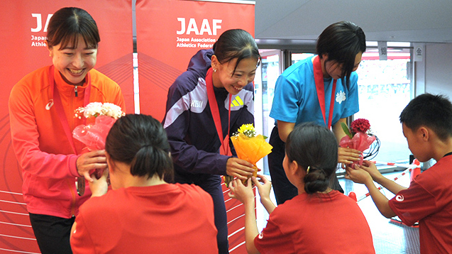 子供たちから花束を手渡されて笑顔を見せる女子800mのメダリストの皆さん